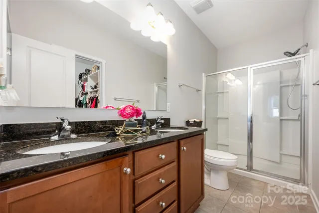 a bathroom with a granite countertop sink mirror vanity and toilet