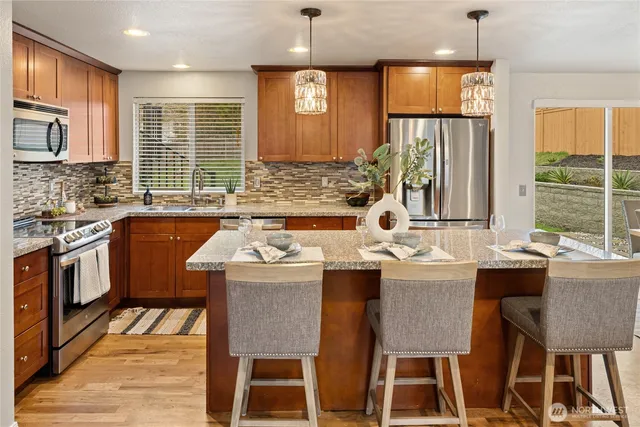 a view of a kitchen with granite countertop a sink and a stove