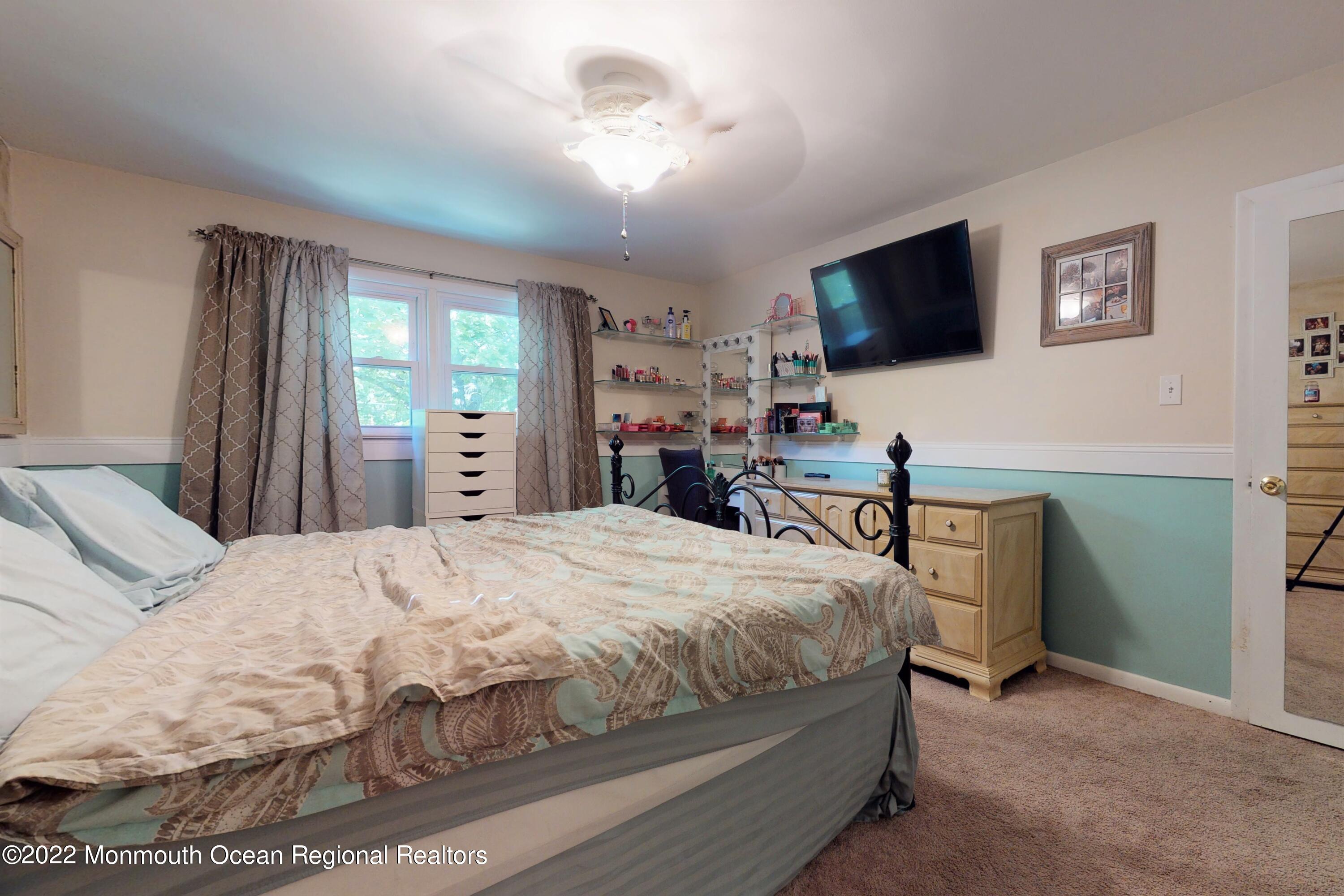 919 Monmouth Road Cream Ridge, NJ 08514 - Photo 11 of 27 a bedroom with a bed and a flat screen tv