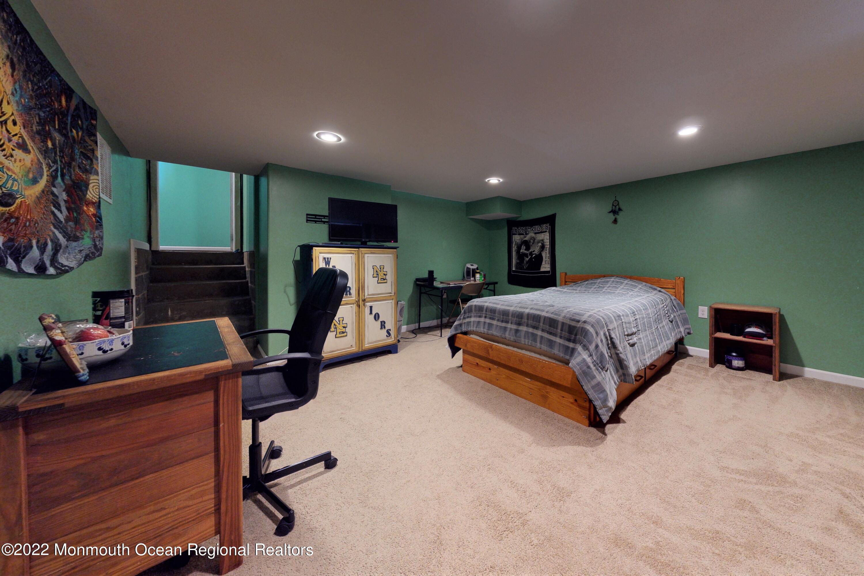 919 Monmouth Road Cream Ridge, NJ 08514 - Photo 16 of 27 a bedroom with a bed a standing fan and a flat tv screen on the dresser