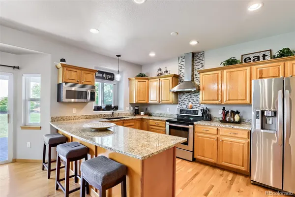 a kitchen with stainless steel appliances granite countertop wooden cabinets stove and refrigerator