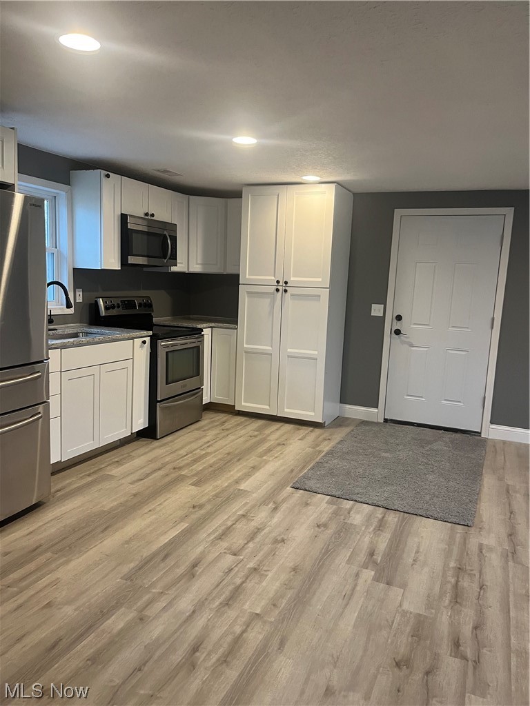 419 Stable Road Lagrange, OH 44050 - Photo 18 of 21 Kitchen featuring sink, light wood-type flooring, range, and refrigerator
