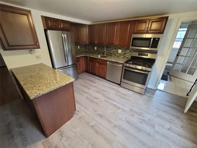 a kitchen with stainless steel appliances granite countertop a refrigerator stove top oven a sink and dishwasher