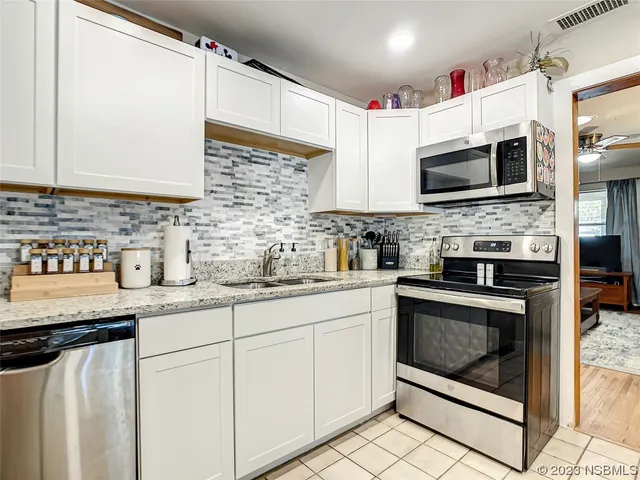 a kitchen with stainless steel appliances granite countertop a stove sink and microwave