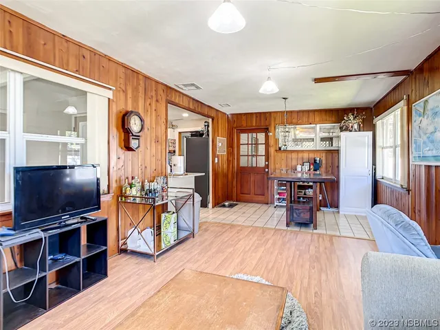 a living room with furniture a flat screen tv and large window