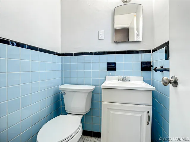 a bathroom with a toilet sink and mirror
