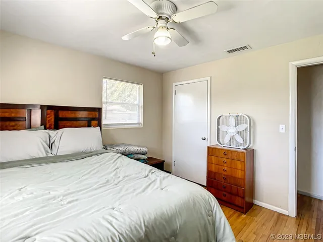 a bedroom with a bed and wooden floor