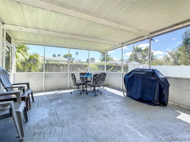 a view of a patio with table and chairs with wooden floor and fence