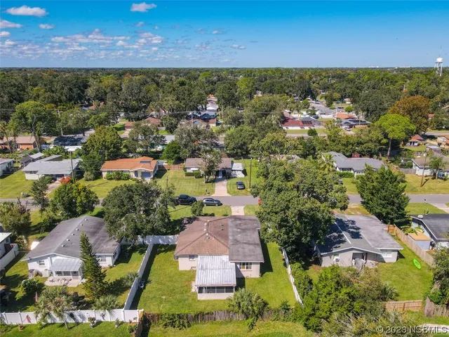 an aerial view of residential houses with outdoor space and trees