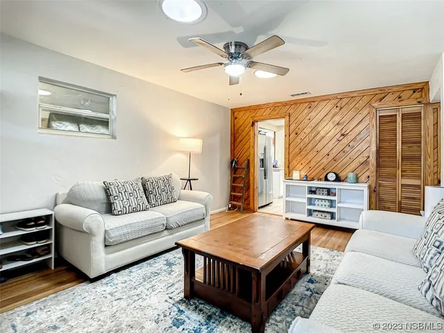 a living room with furniture a flat screen tv and a window