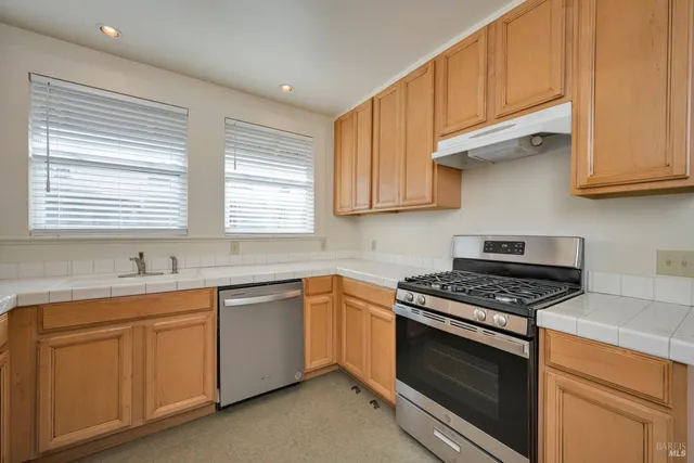 a kitchen with cabinets appliances a sink and a window
