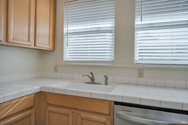 a kitchen with stainless steel appliances white cabinets and a window