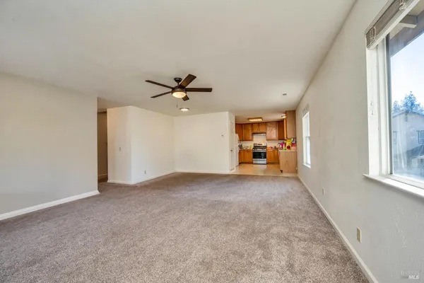 a view of a livingroom with a ceiling fan and window