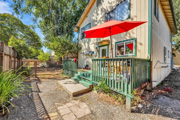 a view of a patio with couches and table and chairs under an umbrella