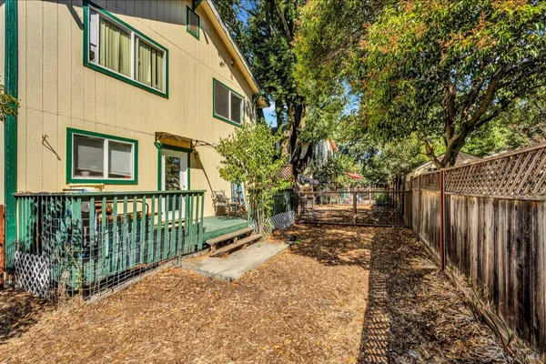 a view of a house with a small yard and wooden fence