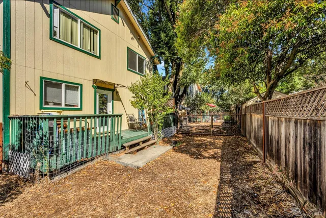 a view of a house with a small yard and wooden fence