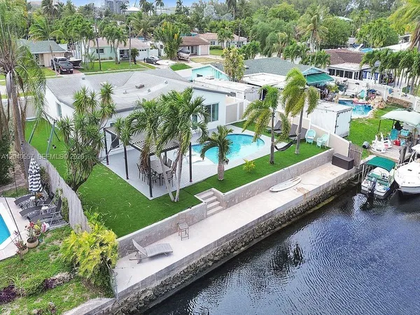 an aerial view of a house with a garden and lake view