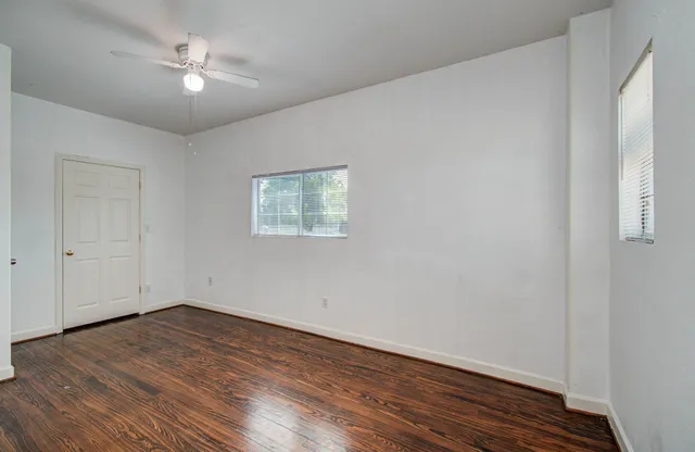 a view of empty room with wooden floor