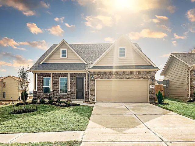 a front view of a house with a yard and potted plants