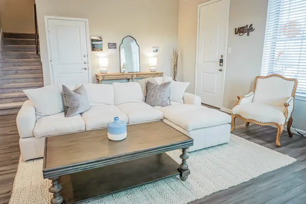 a living room with furniture and a wooden floor