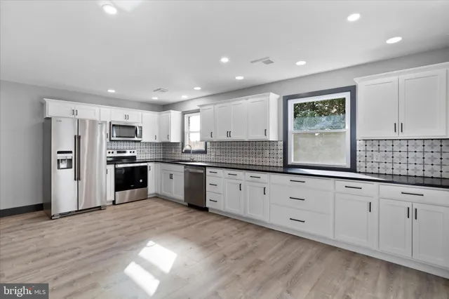 a large kitchen with stainless steel appliances granite countertop a large center island and a sink