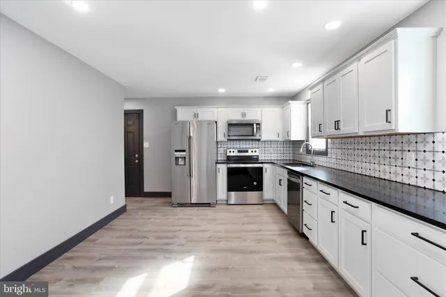 a large kitchen with stainless steel appliances granite countertop a stove and a sink
