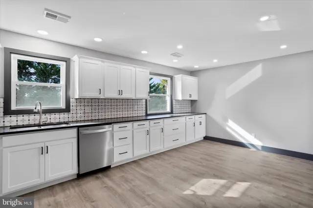 a large kitchen with granite countertop a sink and dishwasher with a large window