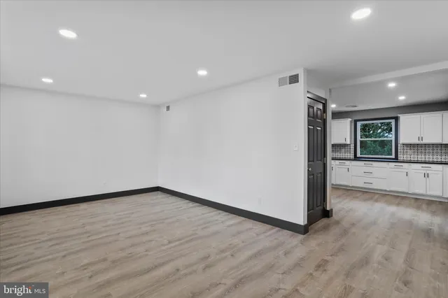 a view of a big room with wooden floor and windows