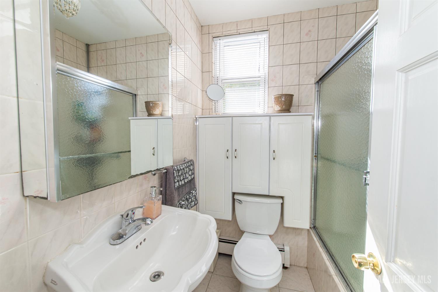 4 Lefferts Street Carteret, NJ 07008 - Photo 11 of 32 a bathroom with a sink toilet and shower