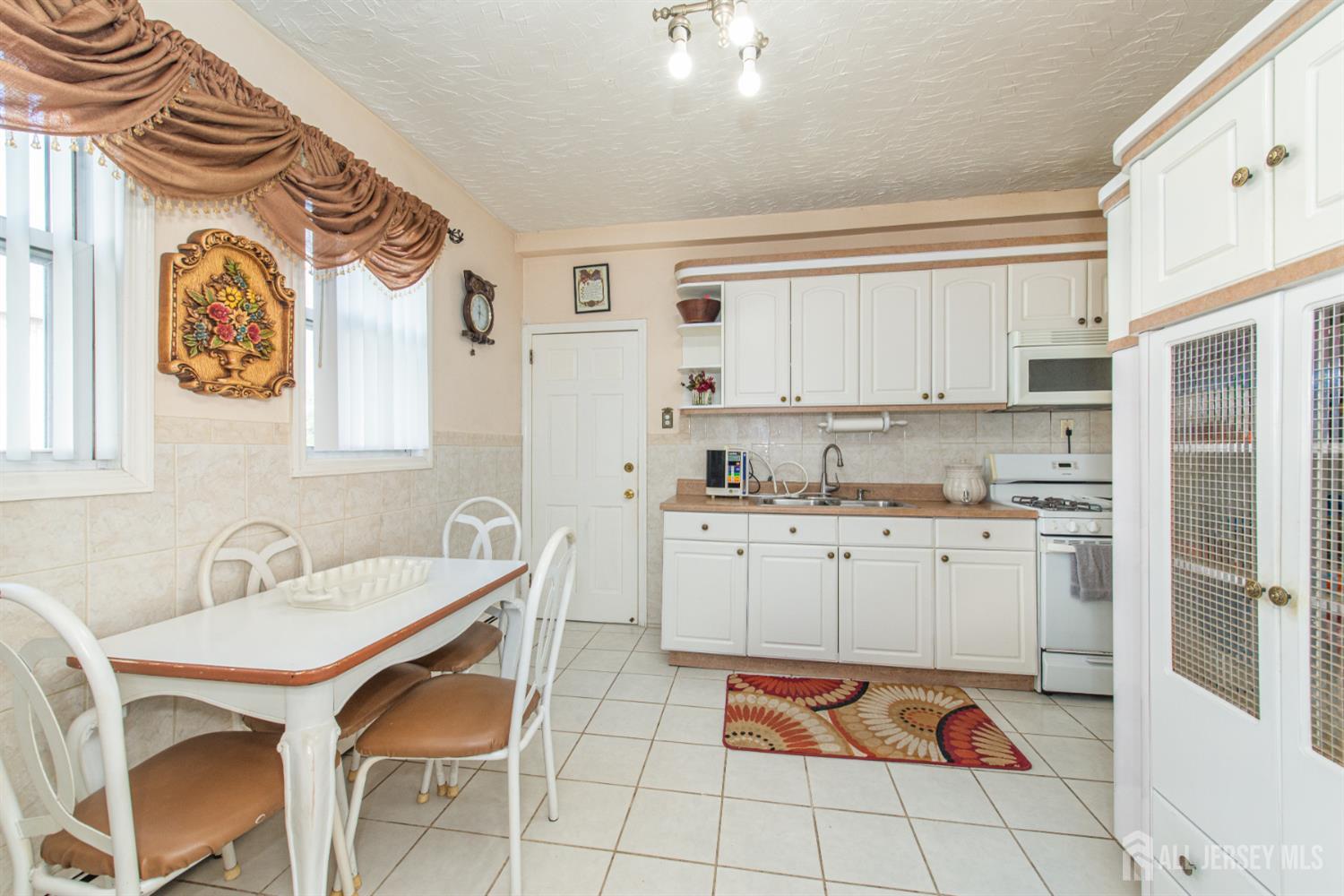 4 Lefferts Street Carteret, NJ 07008 - Photo 12 of 32 a kitchen with stainless steel appliances granite countertop a sink and cabinets