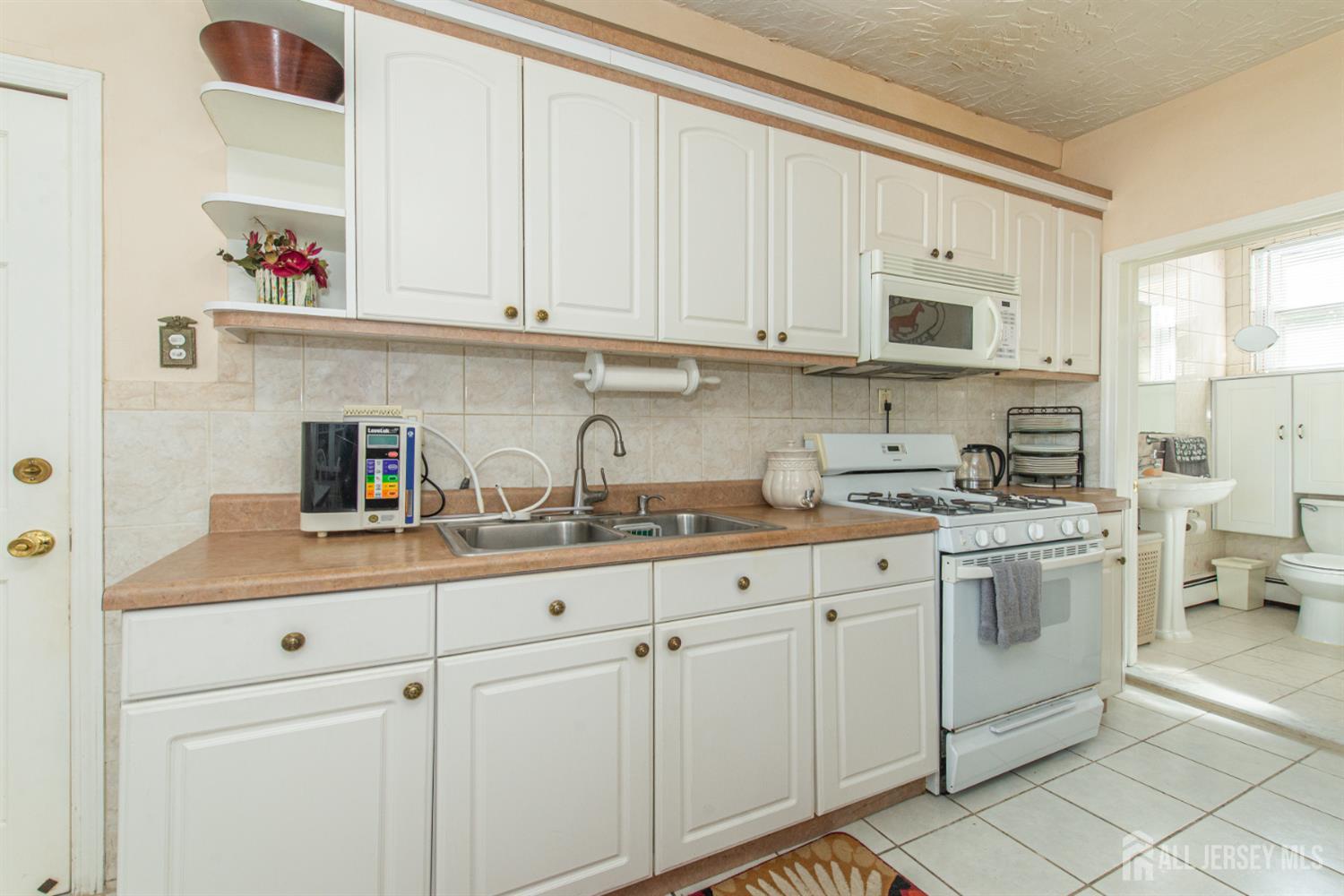 4 Lefferts Street Carteret, NJ 07008 - Photo 14 of 32 a kitchen with stainless steel appliances granite countertop white cabinets a sink and dishwasher