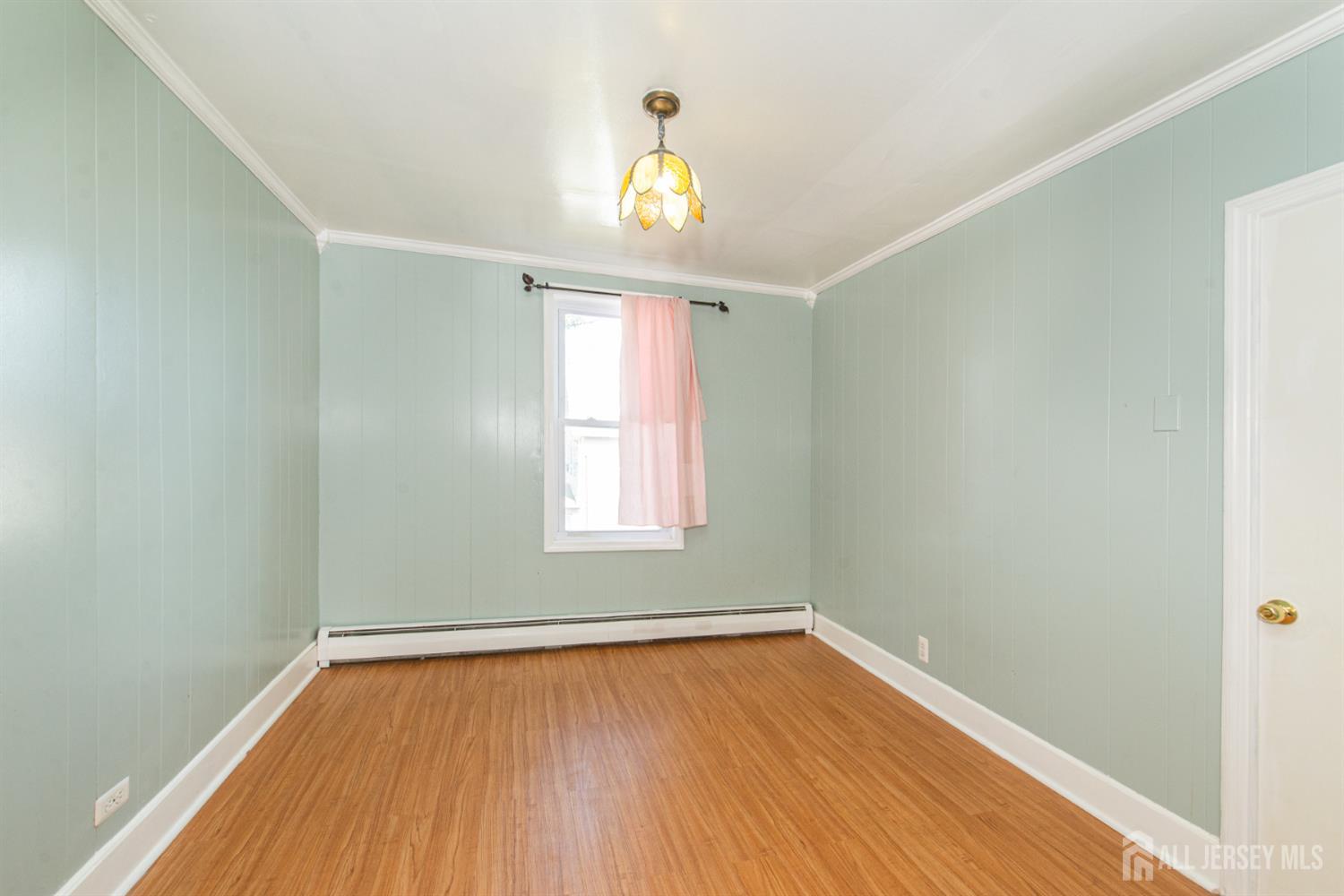 4 Lefferts Street Carteret, NJ 07008 - Photo 22 of 32 a view of empty room with wooden floor and fan
