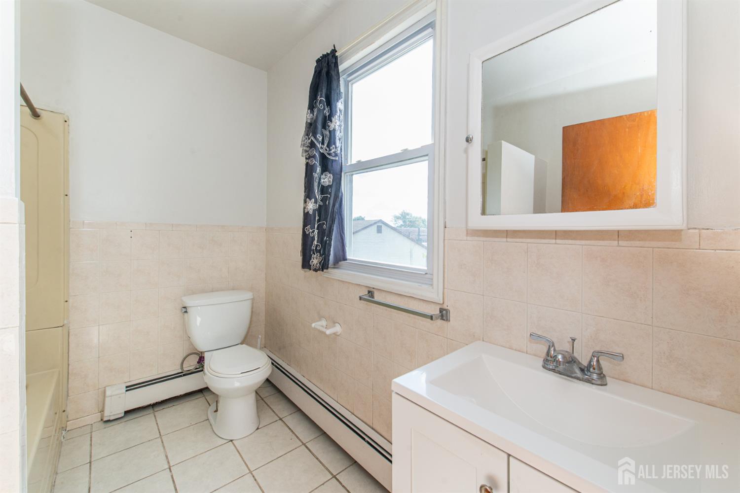 4 Lefferts Street Carteret, NJ 07008 - Photo 27 of 32 a bathroom with a toilet sink and mirror