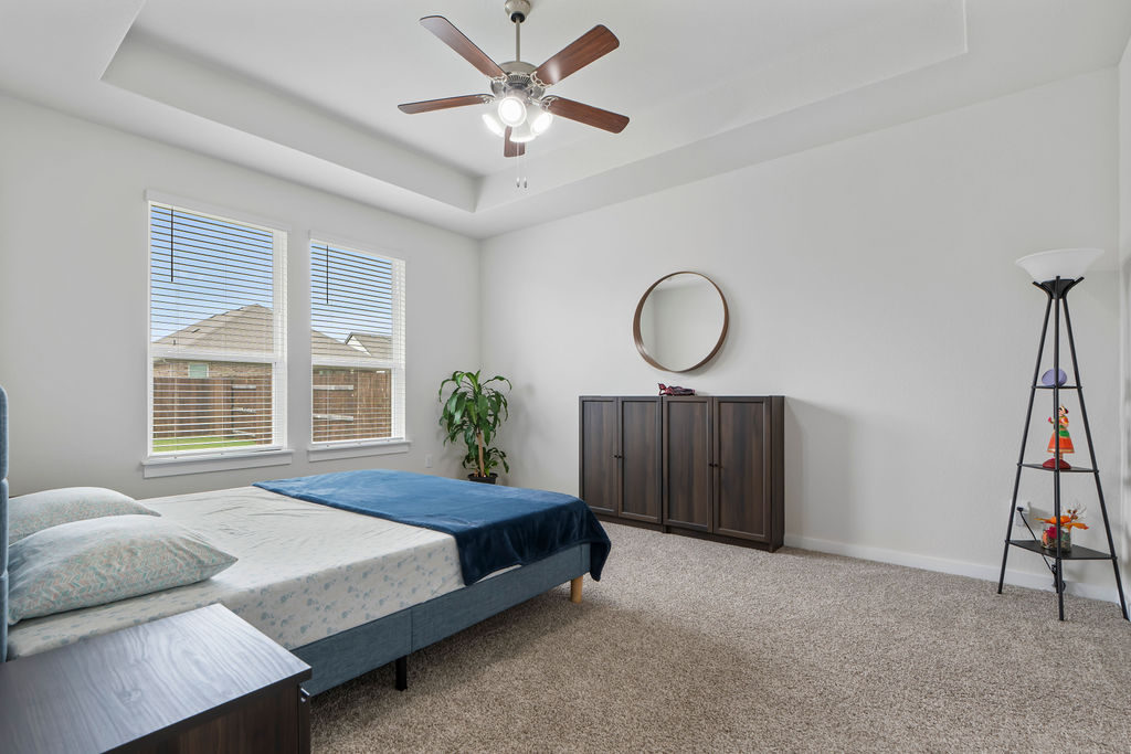 1813 Crow Hop View Leander, TX 78641 - Photo 17 of 33 a spacious bedroom with a bed a window and a potted plant on a dresser