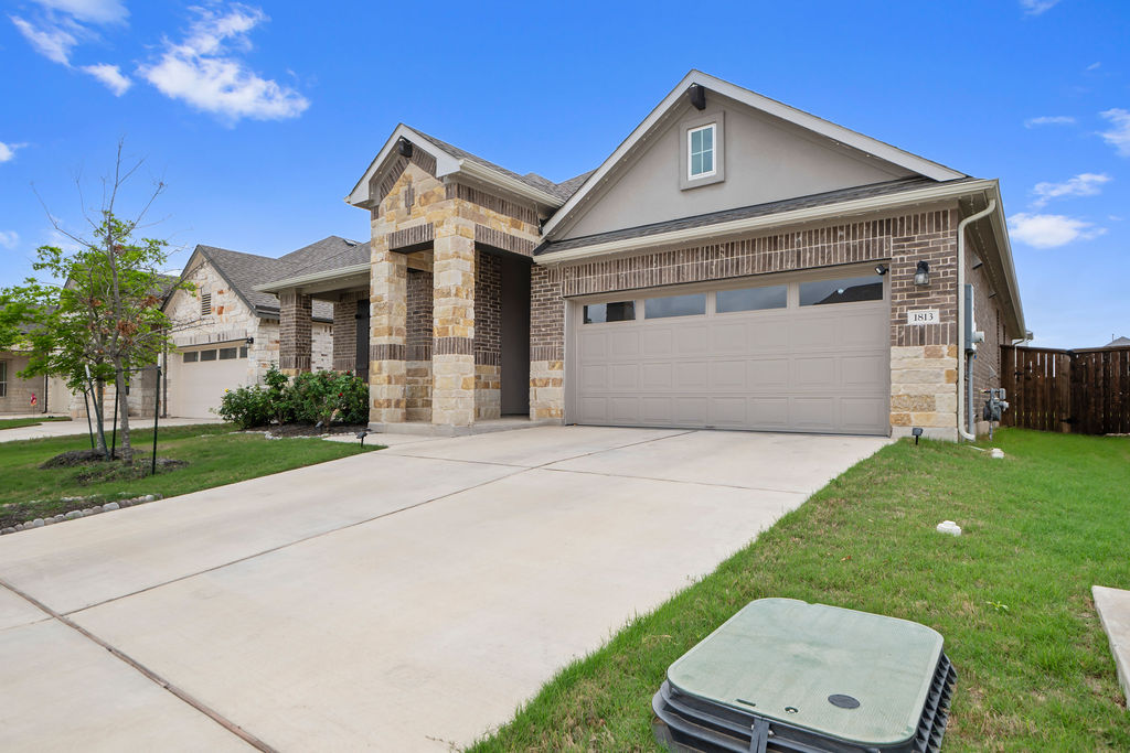 1813 Crow Hop View Leander, TX 78641 - Photo 2 of 33 a front view of a house with a yard and garage