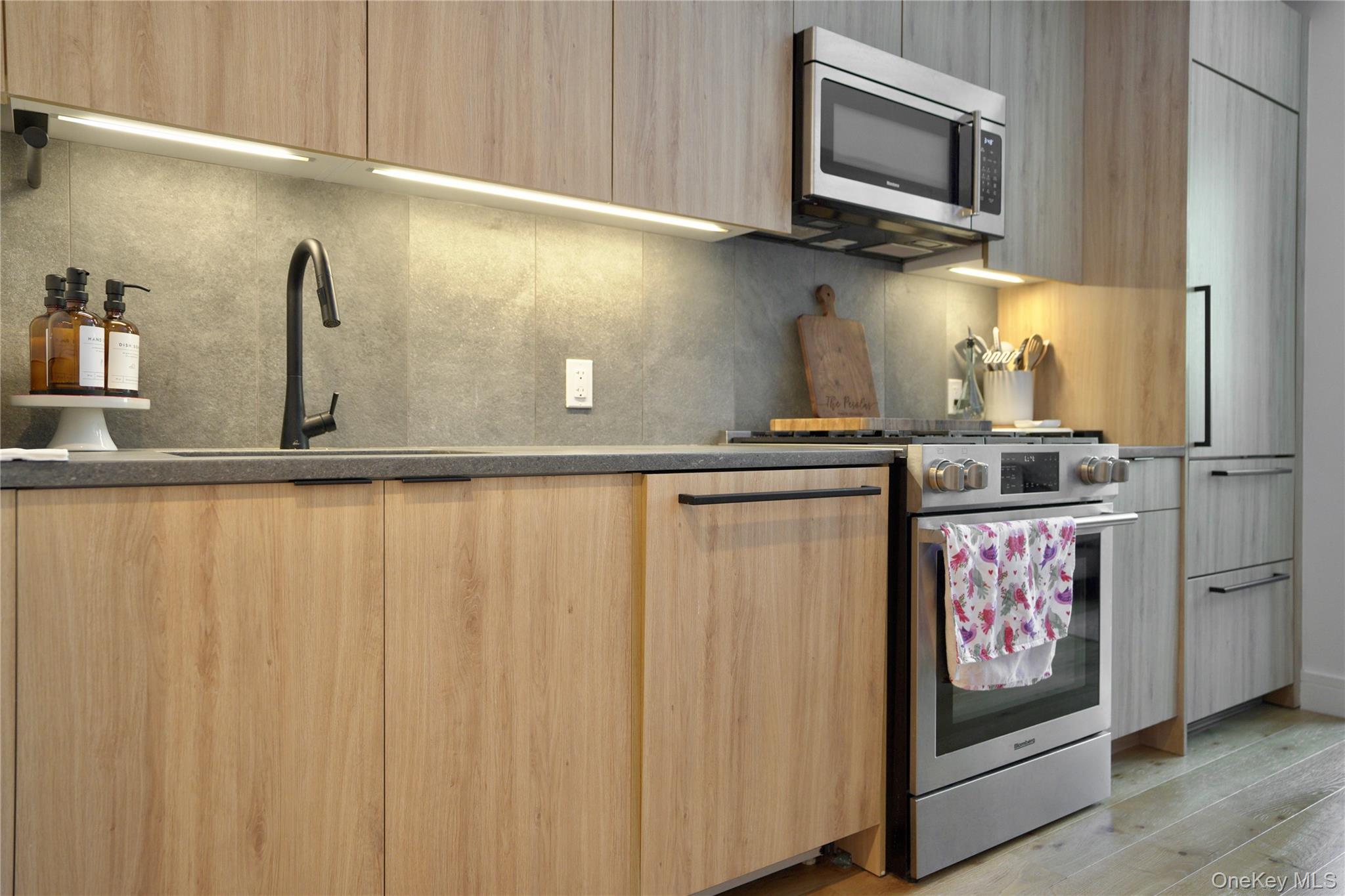 24-16 Queens Plaza South, Unit 2D Queens, NY 11101 - Photo 3 of 28 a kitchen with stainless steel appliances granite countertop a refrigerator and stove