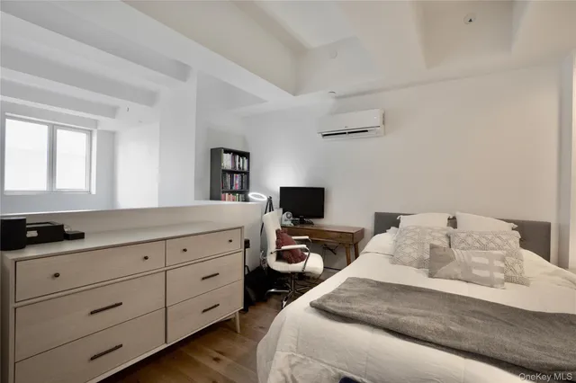 a bedroom with a bed and a flat tv screen on the dresser
