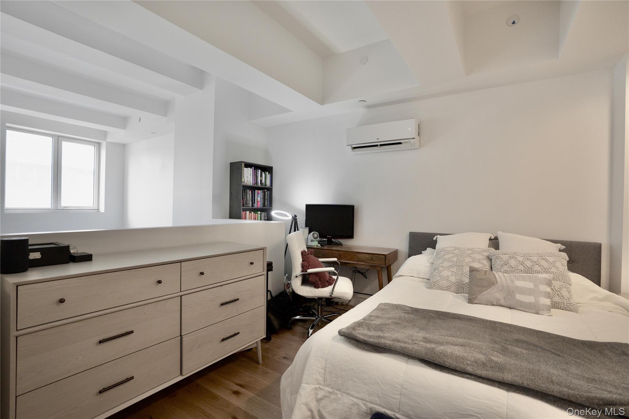 24-16 Queens Plaza South, Unit 2D Queens, NY 11101 - Photo 9 of 28 a bedroom with a bed and a flat tv screen on the dresser