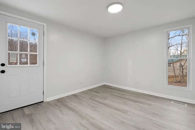a view of an empty room with wooden floor