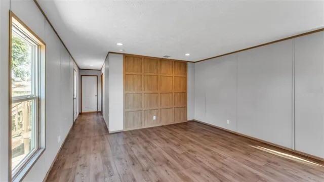 an empty room with wooden floor and sliding door