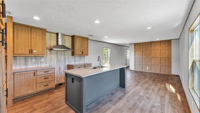 a kitchen with a sink a window and wooden cabinets