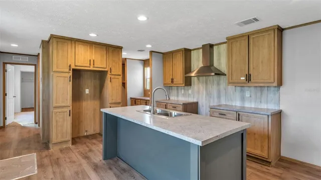a kitchen with kitchen island granite countertop a sink a refrigerator and island