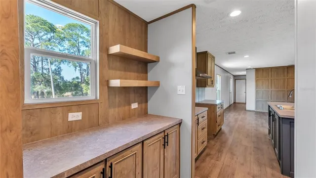a kitchen view with wooden floor a window and stainless steel appliances