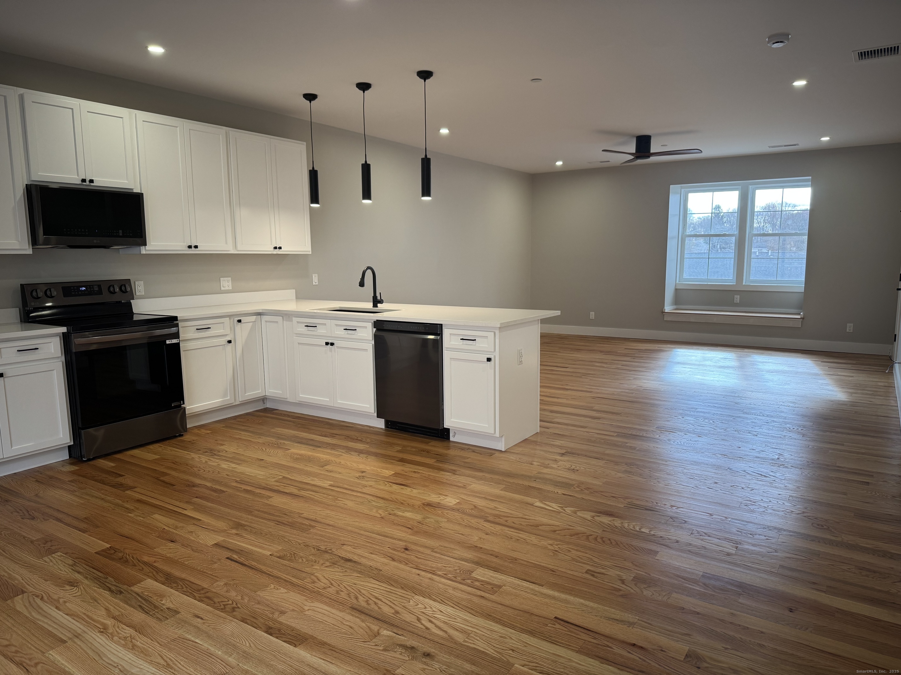 a kitchen with stainless steel appliances granite countertop a stove a sink and a microwave