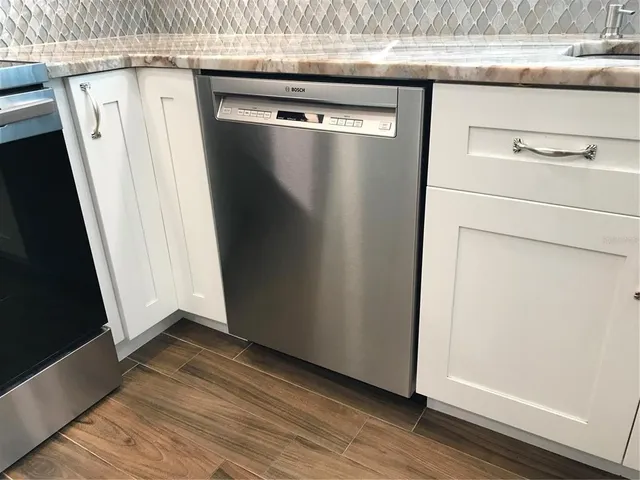 a metallic refrigerator freezer sitting in a kitchen