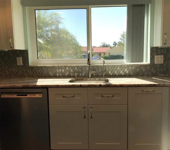 a kitchen with white cabinets and a sink