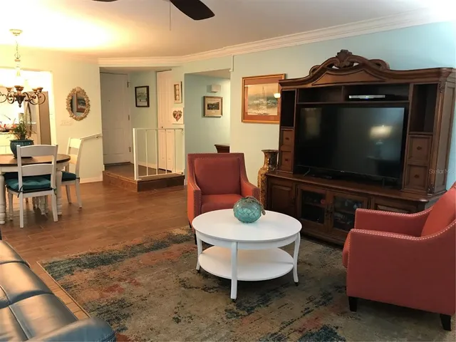 a living room with furniture a flat screen tv and kitchen view