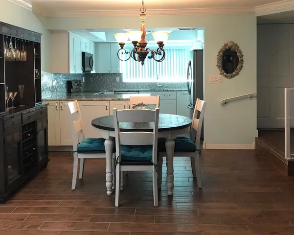 a kitchen with a dining table chairs and granite counter tops