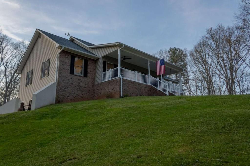 141 Chambers Mountain Road Mineral Bluff, GA 30559 - Photo 4 of 65 a house with green field in front of it