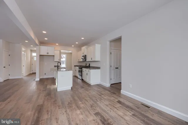 a large kitchen with stainless steel appliances granite countertop a sink stove and refrigerator